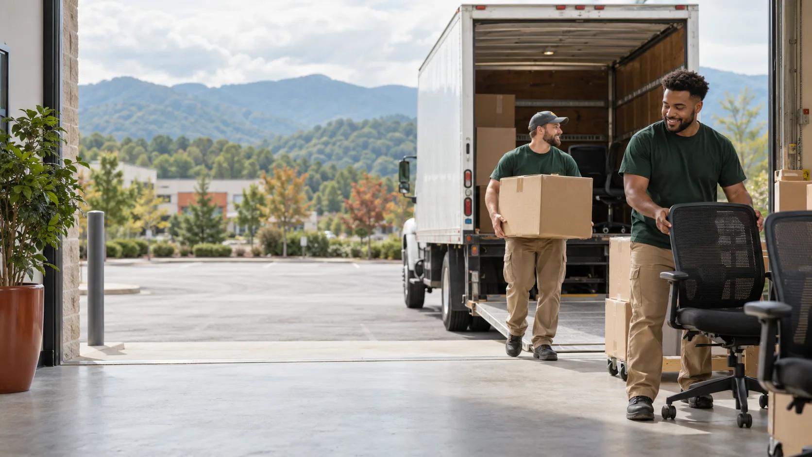 Commercial removal crew moving office chairs and boxes toward a truck